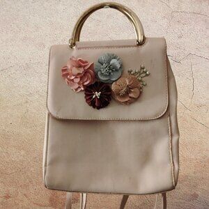 This is a small pink faux leather fashion backpack